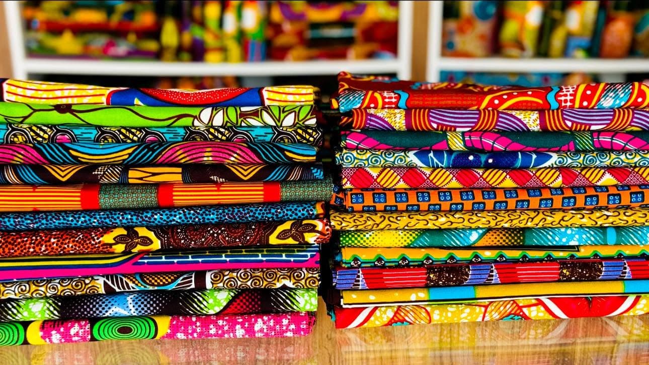 Shelves of folded GTP fabric in the Madina shop